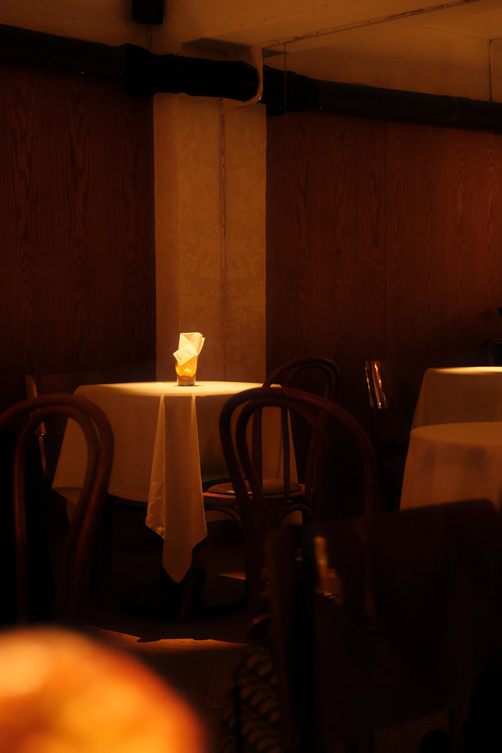 A restaurant table lit by a single candle