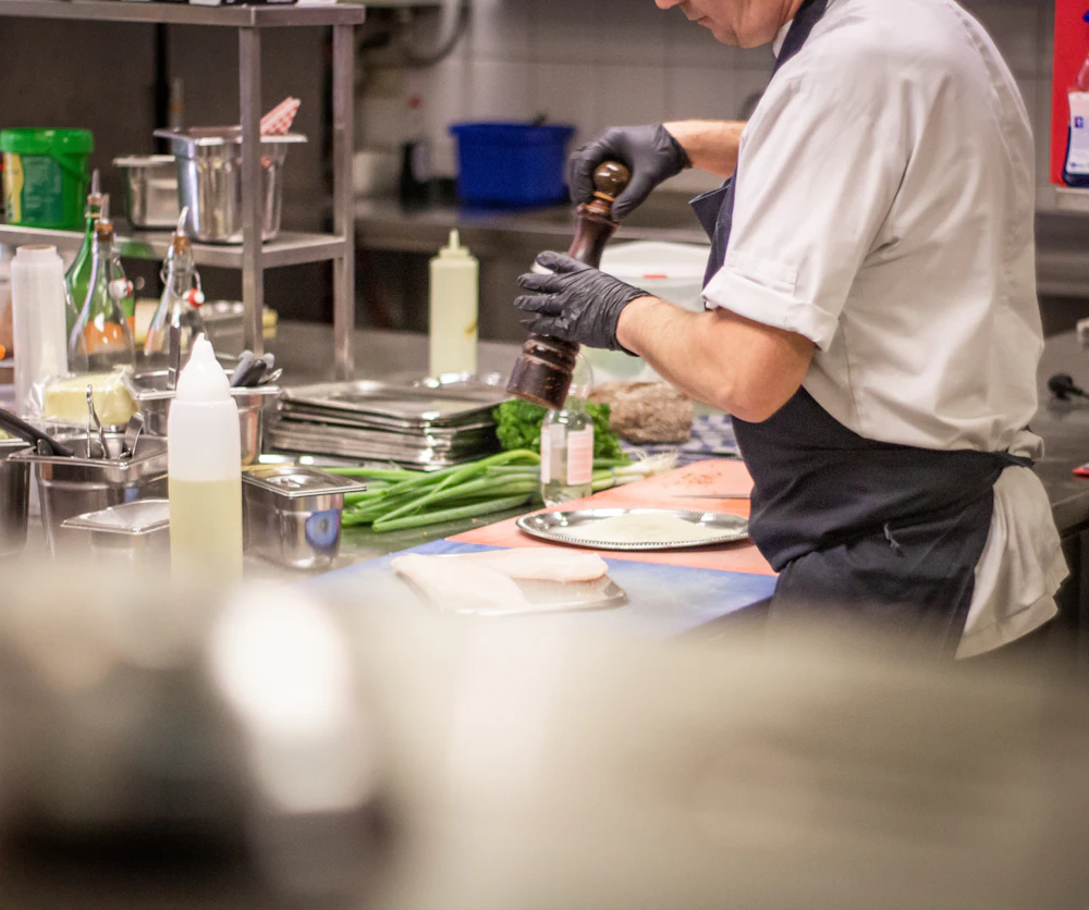 The chef adding herbs to a dish