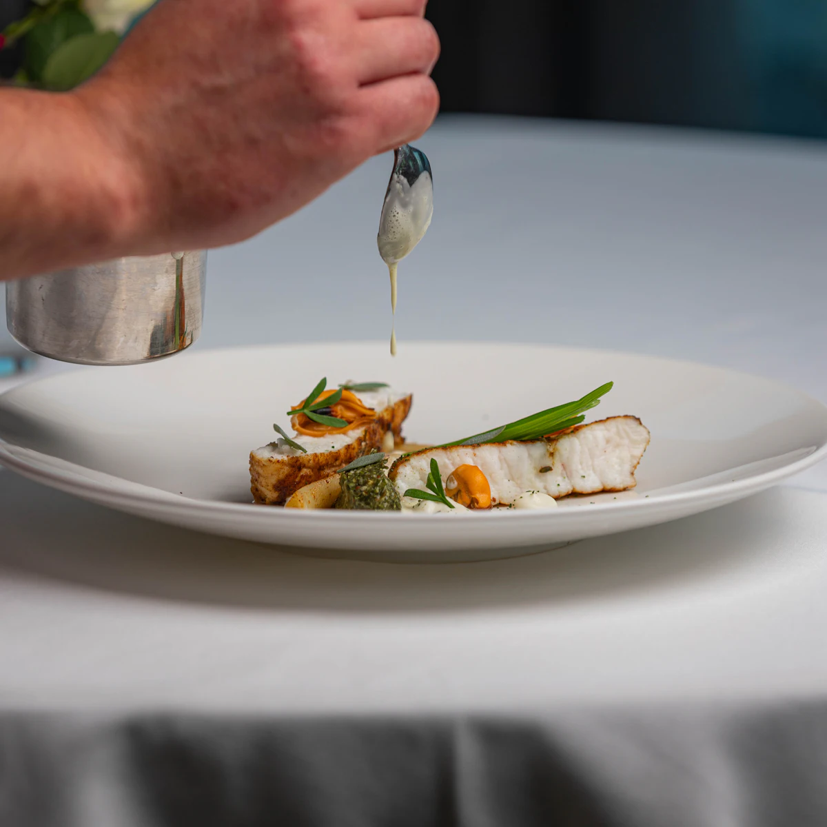 Fish with vegetables on a white plate